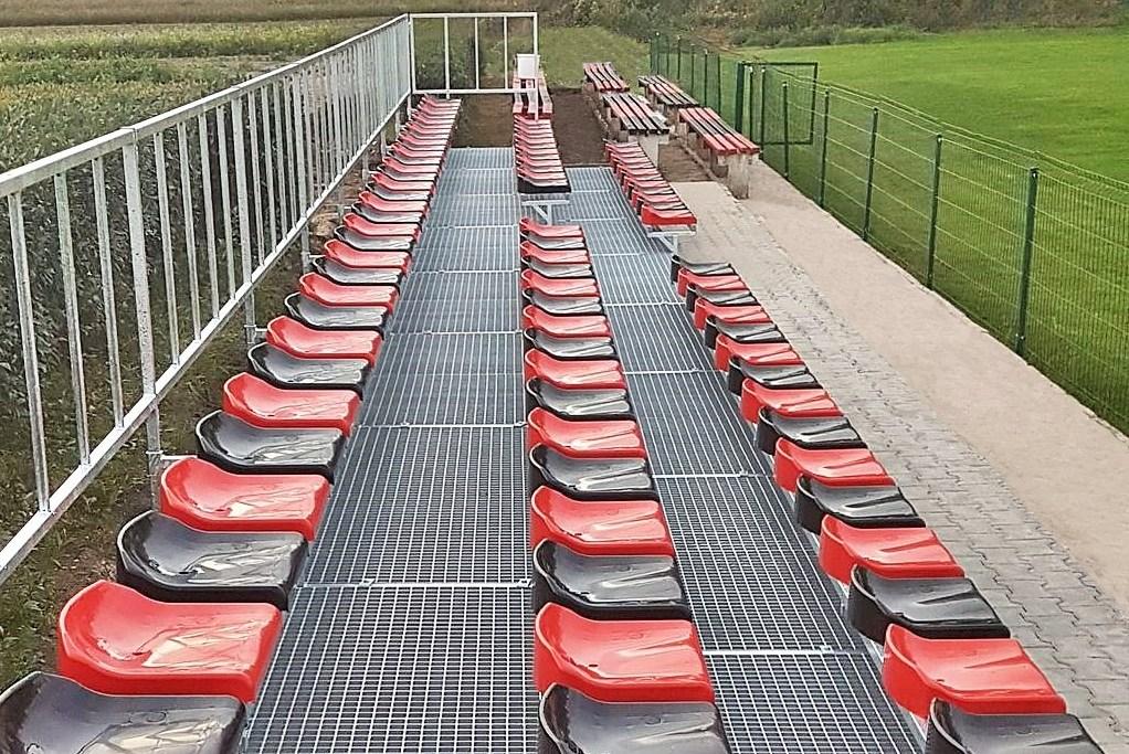 krzesełka stadionowe niskie czerwone i czarne  zainstalowane na trybunie modułowej 
