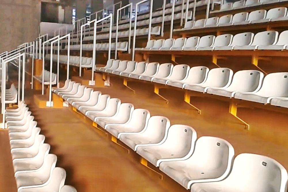 białe siedziska stadionowe na metalowej konstrukcji wsporczej