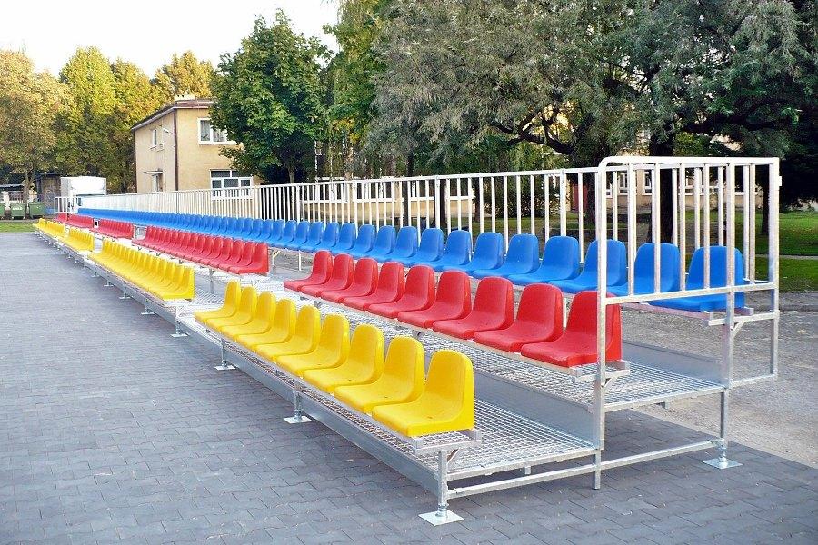 Trzy kolorowe stadionowe krzesła wandaloodporne na trybunie boiskowej  